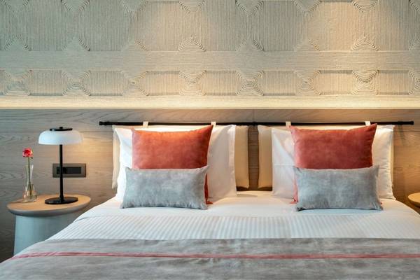 Hotelzimmer im Mitsis Summer Palace mit einem Bett, Kissen und Nachttischen