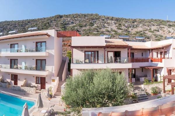 Außenansicht des Cactus Village Hotel & Bungalows mit Swimmingpool und Berg im Hintergrund.