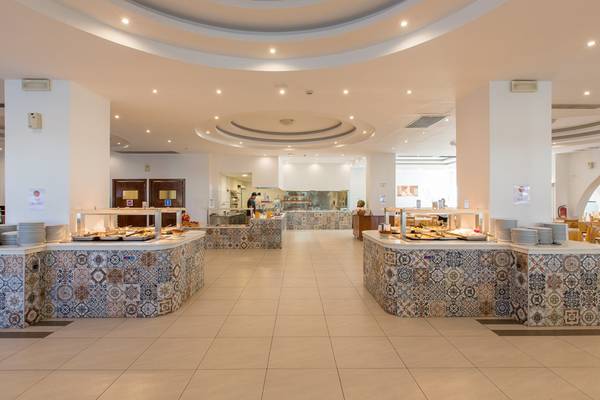 Innenansicht des Buffets im Sun Palace Hotel mit verschiedenen Speisen und gefliesten Wänden.