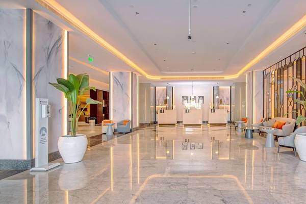 Lobby des Radisson Blu Hotel mit Marmorboden und Pflanzen in weißen Vasen.