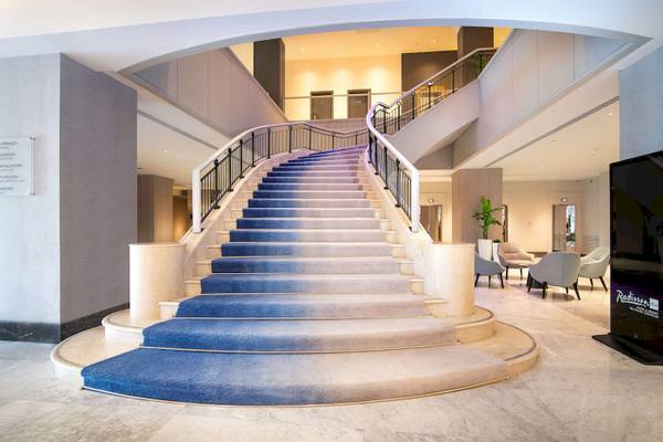 Treppenhaus im Radisson Blu Hotel & Resort, Abu Dhabi Corniche mit blauen Stufen und moderner Inneneinrichtung.