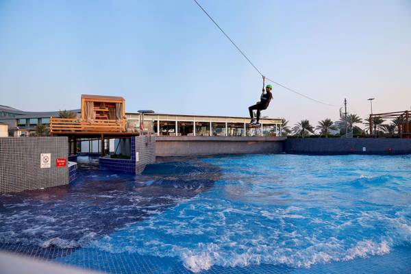Person zippt über eine Wasserwelle am Radisson Blu Hotel & Resort, Abu Dhabi Corniche