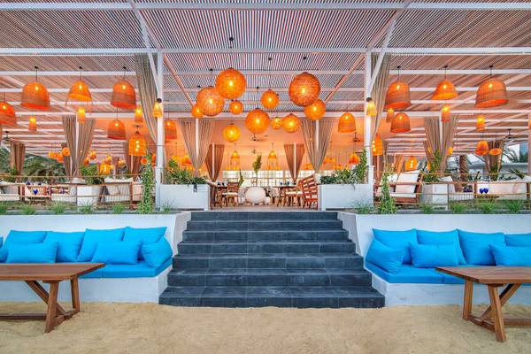 Terrasse des Radisson Blu Hotel & Resort in Abu Dhabi Corniche mit orangefarbenen Lampen und blauen Kissen