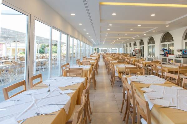 Innenansicht des Speisesaals im Sun Palace Hotel mit gedeckten Tischen und Stühlen.