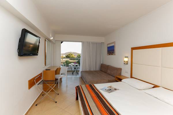 Hotelzimmer im Sun Palace mit Fernseher, Bett, Couch, Schreibtisch und Balkonzugang.
