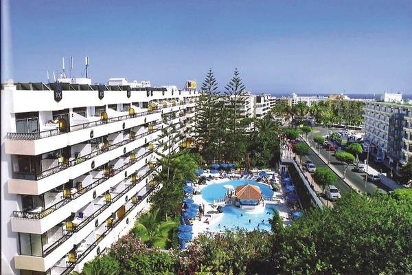 Außenansicht des Rey Carlos Hotels mit Swimmingpool, Gebäuden und belebter Straße