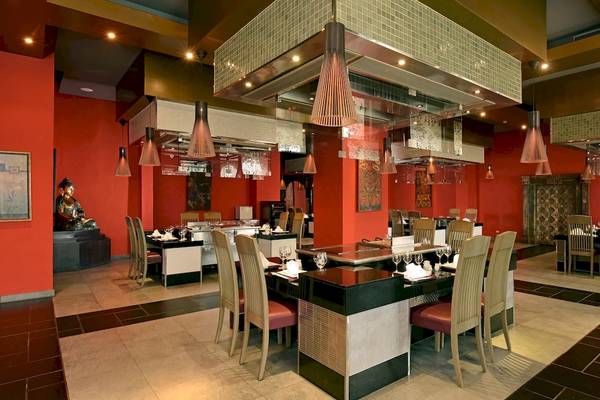 Innenbereich des Restaurants im JOIA Bávaro by Iberostar Hotel mit roten Wänden und modernen Möbeln.