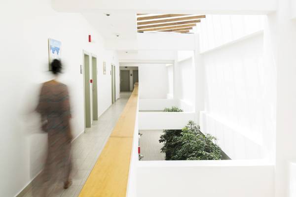 Foto von einem langen Flur im Almyrida Beach Hotel mit weißen Wänden, einem hölzernen Boden und Pflanzen