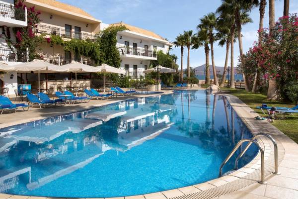 Außenbereich des Almyrida Beach Hotel mit Pool und Liegestühlen.