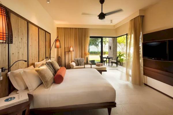 Schlafzimmer im Constance Ephelia Resort mit großem Bett, Fenstern und Blick auf die Terrasse.