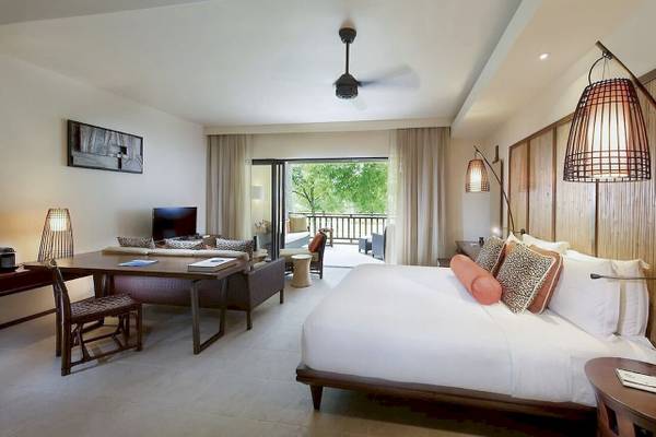 Schlafzimmer im Constance Ephelia Resort mit großem Bett, Schreibtisch und Balkon.