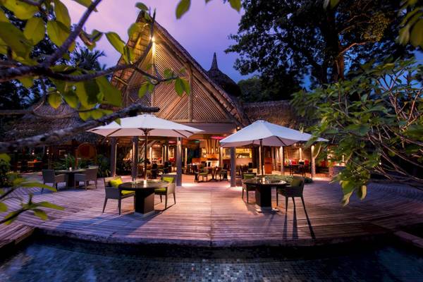 Terrasse des Constance Ephelia Resorts bei Nacht mit beleuchteten Tischen und Stühlen.
