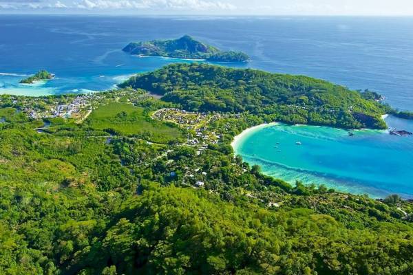 Luftaufnahme des Constance Ephelia Resorts auf einer Insel mit türkisfarbenem Wasser und grüner Vegetation.