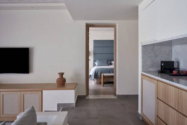 Innenansicht des Atlantica Beach Resort Kos mit modernem Wohnbereich und Schlafzimmer.