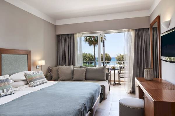 Zimmer im Atlantica Beach Resort Kos mit Blick auf das Meer und einen Balkon.
