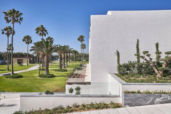 Außenbereich des Atlantica Beach Resort Kos mit weißen Gebäuden und Palmen
