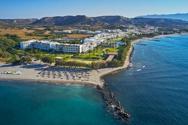 Gesamtansicht des Atlantica Beach Resort Kos am Strand mit vielen Liegestühlen und Hotelgebäuden.