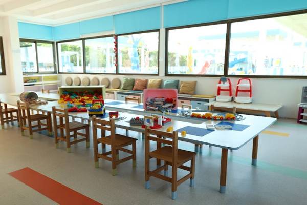 Foto des Kinderspielbereichs im Nirvana Cosmopolitan Hotel mit Tischen, Stühlen und Spielzeug.