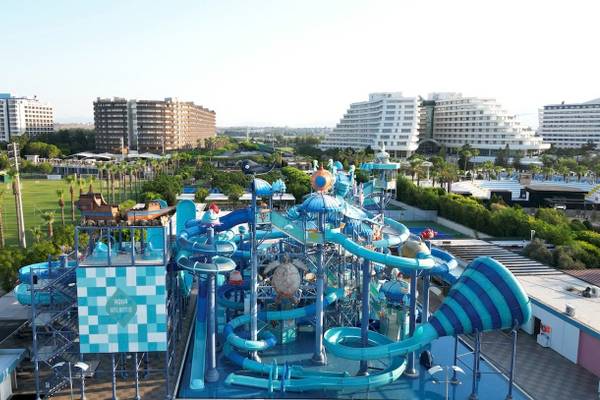 Luftaufnahme des Nirvana Cosmopolitan Wasserparks mit vielen Rutschen und Gebäuden im Hintergrund.