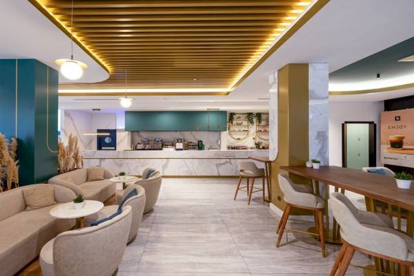 Loungebereich des Nirvana Cosmopolitan Hotels mit modernen Möbeln und einer Bar.