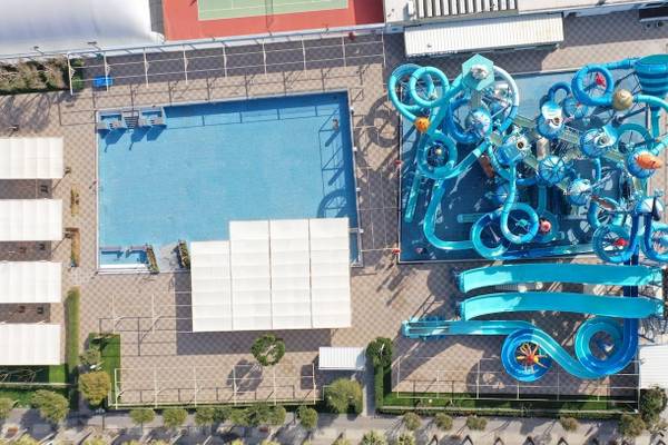 Luftaufnahme des Nirvana Cosmopolitan Hotels zeigt einen großen Wasserpark mit blauen Rutschen und einem großen Schwimmbad.