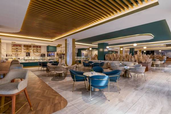Innenbereich des Nirvana Cosmopolitan Hotels mit modernen Möbeln, grünen Wänden und Holzboden.