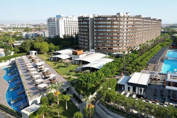 Luftaufnahme des Nirvana Cosmopolitan Hotels mit Swimmingpool und umliegenden Gebäuden.