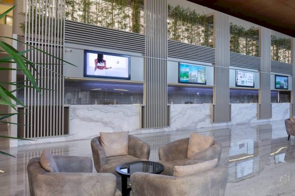 Lobby-Sitzbereich des Nirvana Cosmopolitan Hotels mit Marmorboden und Monitoren.