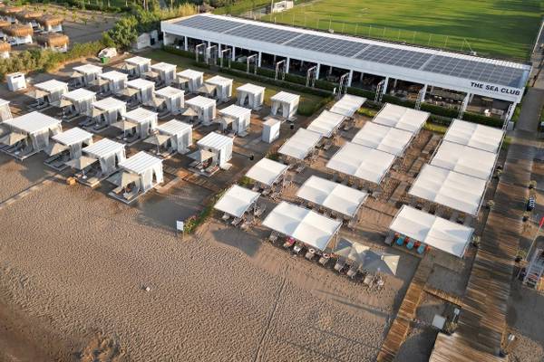 Luftaufnahme des Nirvana Cosmopolitan Hotels mit weißen Zelten und Solarmodulen am Strand
