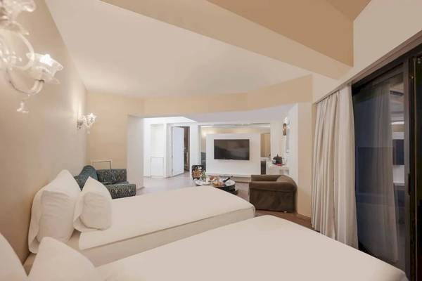 Doppelzimmer im Megasaray Resort Side mit zwei Betten, Fernseher und Sofa.