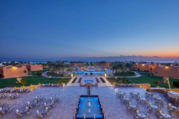 Luftaufnahme des Jaz Grand Marsa Hotels mit Swimmingpools und Außenbereichen bei Sonnenuntergang.