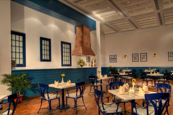 Innenbereich des Jaz Grand Marsa Restaurants mit blauen Stühlen und Tischen.