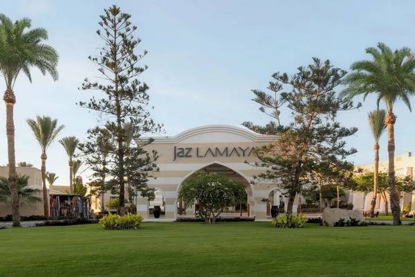 Eingang des Jaz Lamaya Resorts mit Palmen und Rasen.