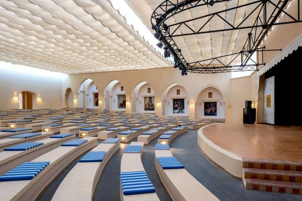 Innenansicht des Auditoriums im Jaz Lamaya Resort mit Sitzreihen und Bühnenbeleuchtung.