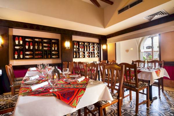 Innenansicht des Restaurants im Jaz Lamaya Resort mit gedeckten Tischen und Stühlen.