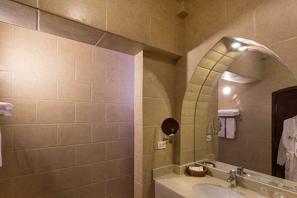 Badezimmer im Utopia Beach Club mit einer Dusche, Waschbecken und Spiegel.