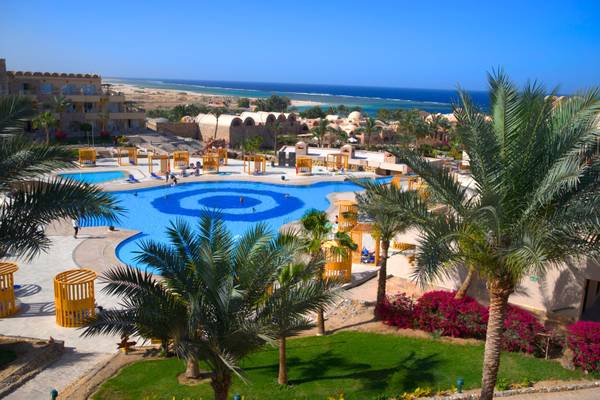 Luftaufnahme des Utopia Beach Club Resorts mit Swimmingpool und Meer im Hintergrund.