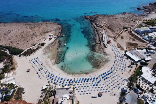 Luftaufnahme des Anonymous Beach mit blauem Wasser und vielen Liegestühlen