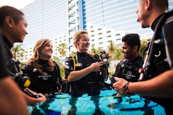 Gruppe von Tauchern bereitet sich vor dem Jumeirah Beach Hotel vor.
