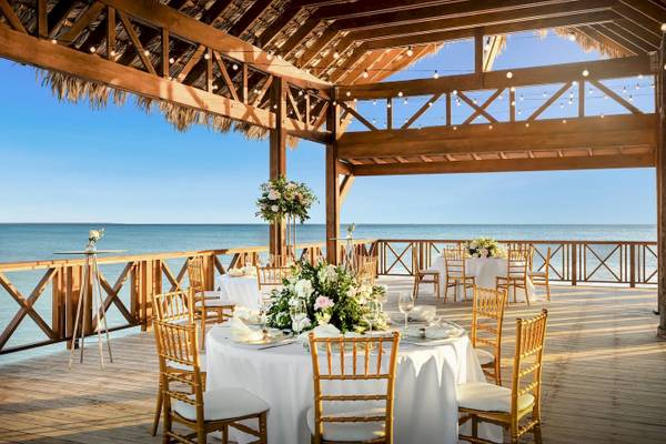 Foto von der Terrasse des Sunscape Dominicus La Romana mit Blick auf das Meer und gedeckten Tischen.