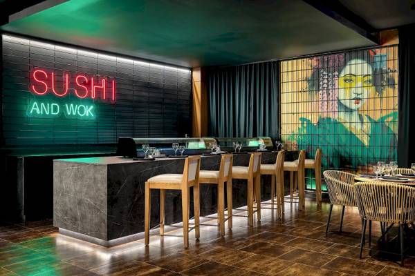 Innenansicht des Sushi und Wok Restaurants im Sunscape Dominicus La Romana mit einer neonroten Beleuchtung und einer Wandmalerei.