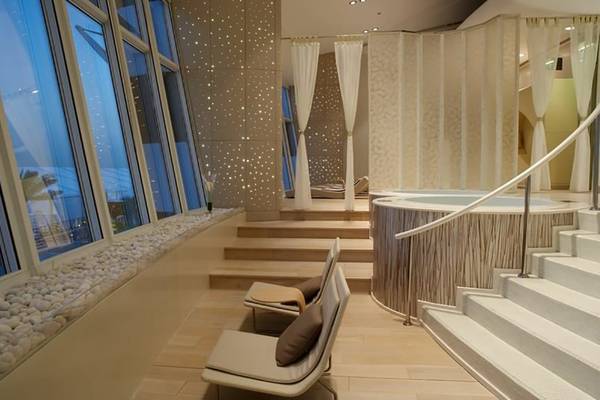 Innenansicht des Spa-Bereichs im Jumeirah Beach Hotel mit Badewanne, Sitzgelegenheiten und Fenstern.