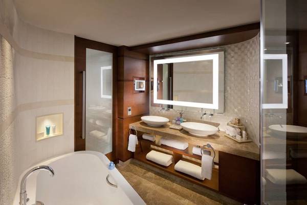 Ein elegantes Badezimmer im Jumeirah Beach Hotel mit Badewanne, Waschbecken und Spiegel.