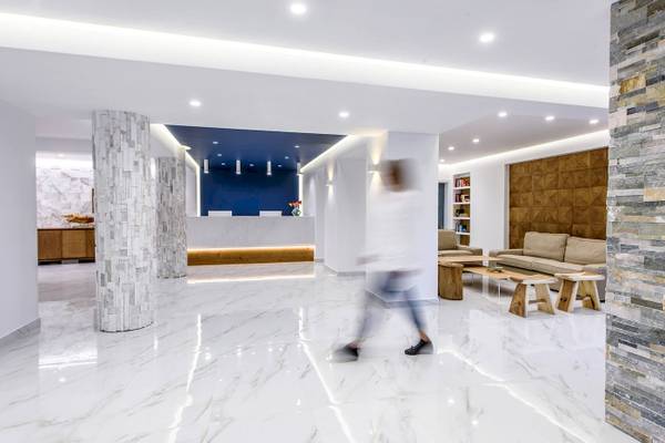 Lobby des Arminda Hotel & Spa mit weißen Marmorboden und modernen Möbeln.