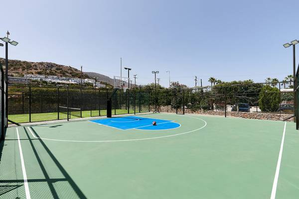 Basketballplatz am Arminda Hotel & Spa mit umzäuntem Bereich und grünem Spielfeld.