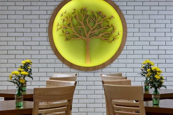 Arminda Hotel & Spa Innenraum mit Baum Wandkunst und Tischen mit Blumenvasen.