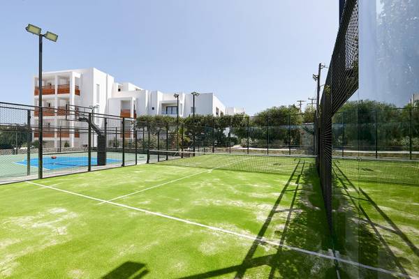 Tennisplatz vor dem Arminda Hotel & Spa mit grünem Kunstrasen und weißem Netz.