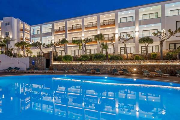 Arminda Hotel & Spa Nachtansicht mit Pool und Liegestühlen.