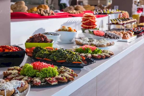 Buffet im Corissia Beach Hotel mit verschiedenen Speisen auf einem langen Tisch.