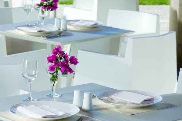 Restauranttisch des Sheraton Rhodes Resort mit Tischdeko und serviertem Geschirr.